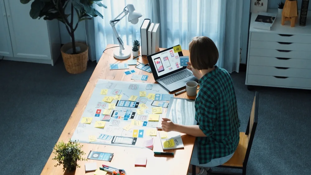 Woman working on a desk with a laptop and a few notes